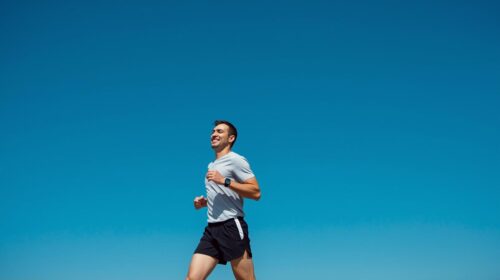 青空の下、男性がジョギング様子