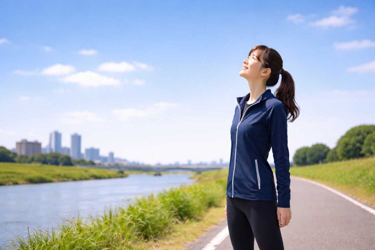 川沿いの道、空を見上げている女性